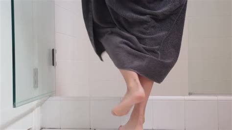 woman drops towel|Woman drops towel as she enters shower .